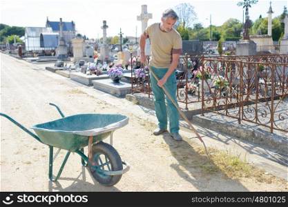 Man weeding around graves