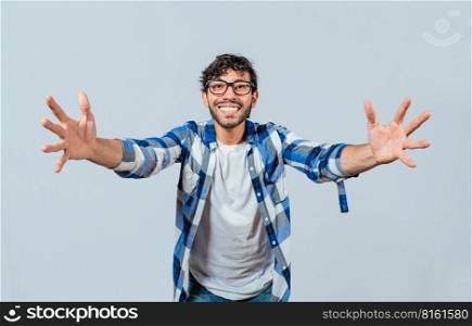 Man welcoming with open arms isolated. Friendly person welcoming. Generous young man with open arms isolated, Man sharing with open hands looking at the camera with a friendly smile