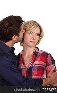 Man whispering in an unhappy woman&acute;s ear
