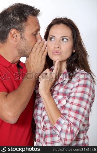 Man whispering to his girlfriend ear