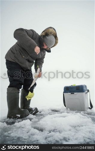 man winter clothes fishing alone outside 2