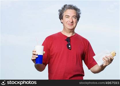 Man with a drink and a hot dog