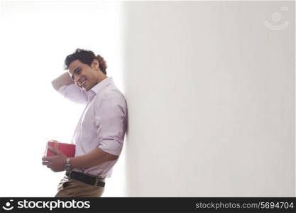 Man with a gift leaning against wall
