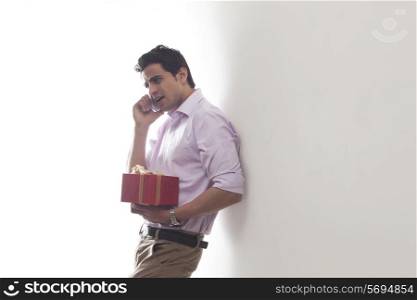 Man with a gift talking on a mobile phone