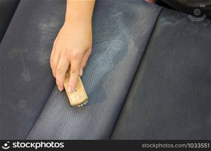 man with a hand to scrub brush to clean upholstery