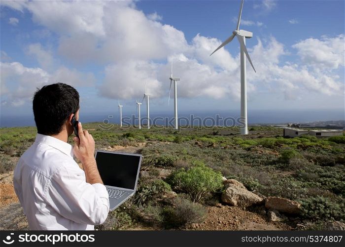 Man with a laptop at a windfarm