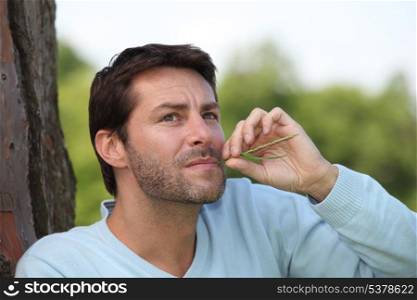Man with a piece of grass in his mouth