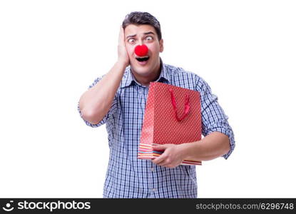 Man with a red nose funny holding a shopping bag gift present is. Man with a red nose funny holding a shopping bag gift present isolated on white background