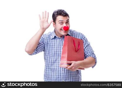 Man with a red nose funny holding a shopping bag gift present is. Man with a red nose funny holding a shopping bag gift present isolated on white background