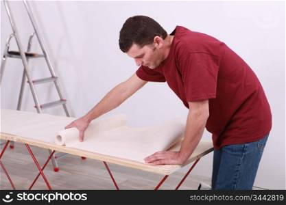 Man with a roll of wallpaper