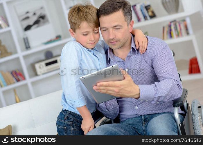 man with a tablet and a boy