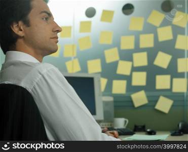 Man with adhesive notes in his office