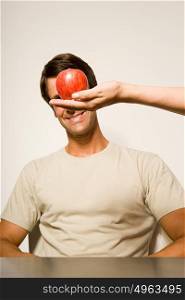 Man with apple in front of his face