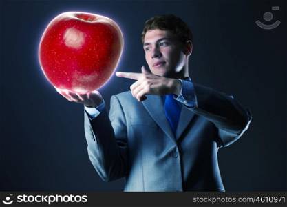 Man with apple. Young businessman holding red apple in hand