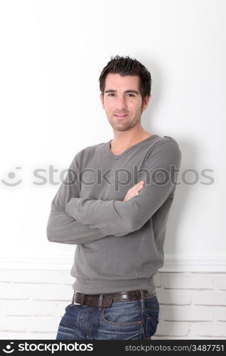 Man with arms crossed standing on white background