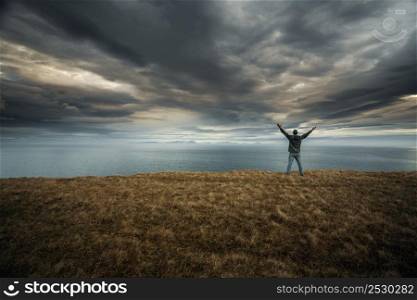 Man with arms raised enjoying the nature in Iceland