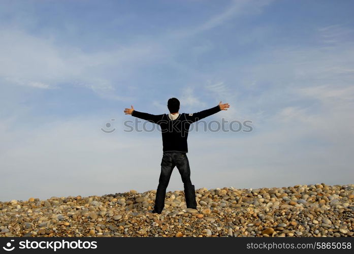 man with arms wide open at the beach