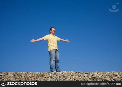 man with arms wide open at the beach