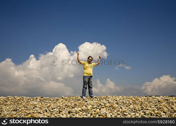 man with arms wide open at the beach