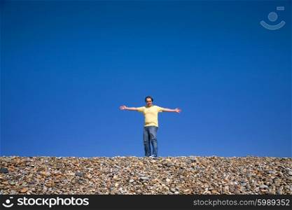 man with arms wide open at the beach