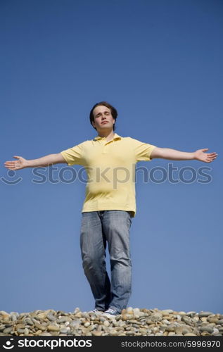 man with arms wide open at the beach