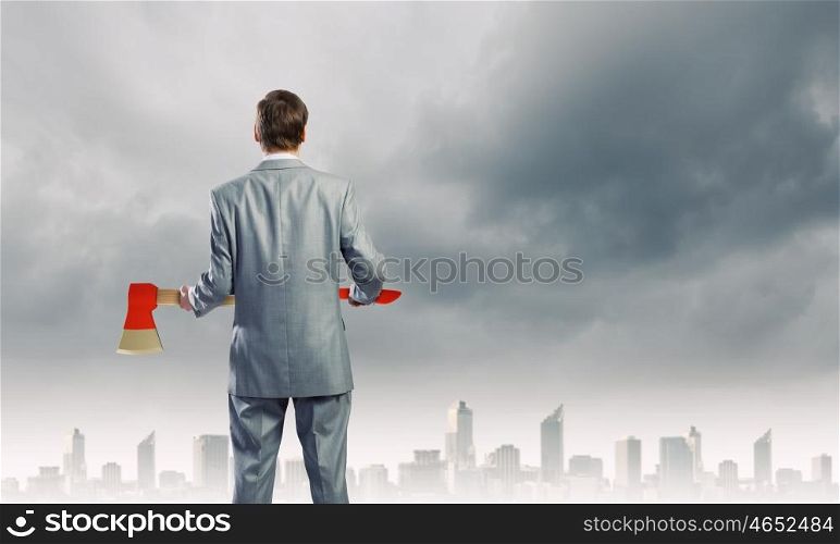 Man with axe. Rear view of young determined businessman with axe in hands