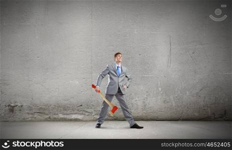Man with axe. Young determined businessman with axe in hands