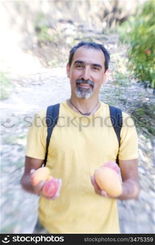 Man with Backpack Holding Mangos