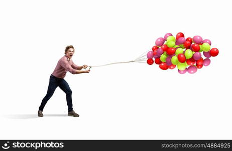 Man with balloons. Young man in casual holding bunch of colorful balloons