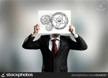 Man with banner. Businessman hiding his face behind paper with drawing