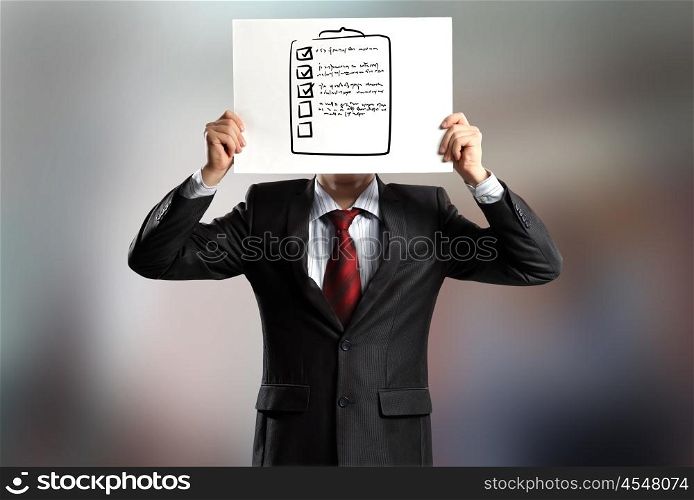 Man with banner. Businessman hiding his face behind paper with drawing