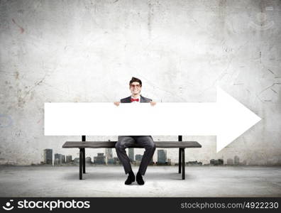 Man with banner. Young man in glasses sitting on bench with white banner