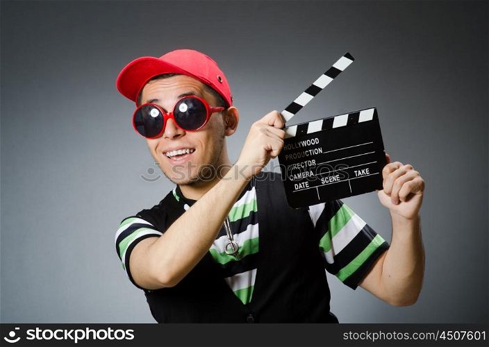 Man with baseball cap and movie board