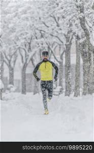 Man with beard trains by running in the snow in a cold winter