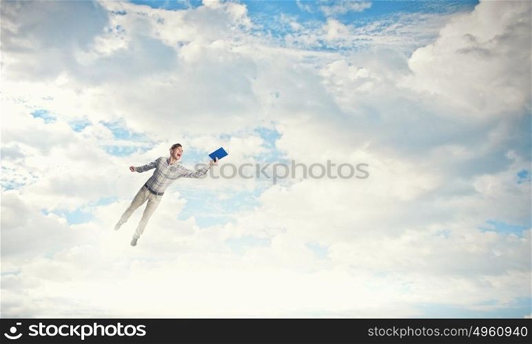 Man with book in hand. Young handsome man on sky background reaching hand with book