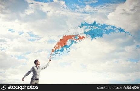 Man with book in hand. Young handsome man reaching hand with book and colorful splashes flying out of pages