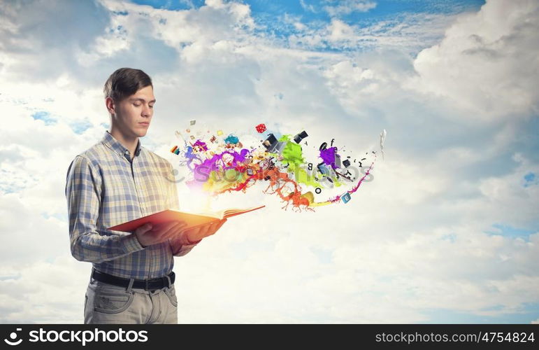 Man with book in hand. Young handsome man reaching hand with book and colorful splashes flying out of pages