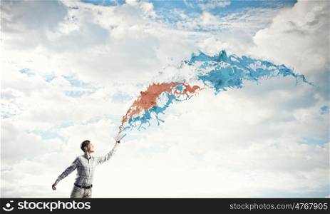 Man with book in hand. Young handsome man reaching hand with book and colorful splashes flying out of pages