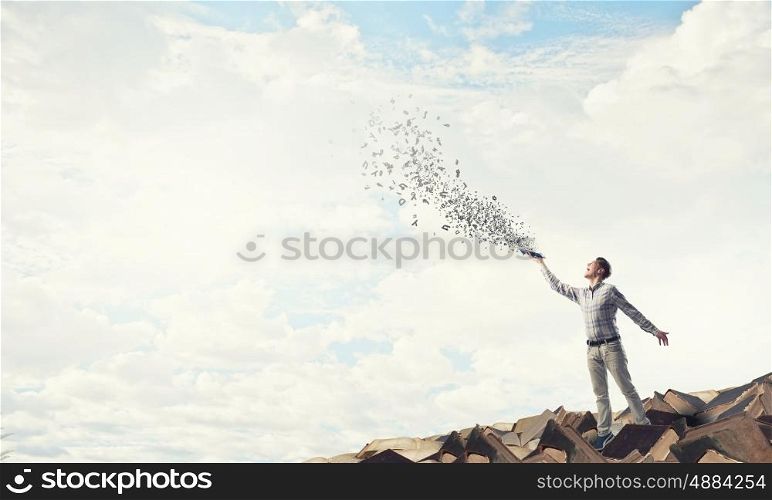 Man with book in hand. Young handsome man reaching hand with book and characters flying out