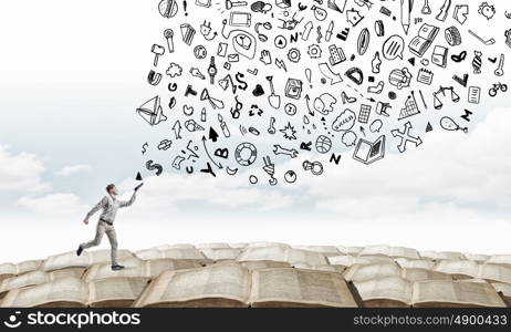 Man with book in hand. Young handsome man reaching hand with book and characters flying out