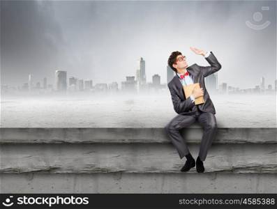 Man with book. Young businessman with book in hands sitting on top