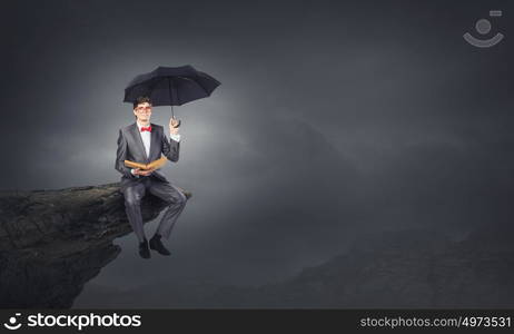 Man with book. Young businessman with book in hands sitting on top