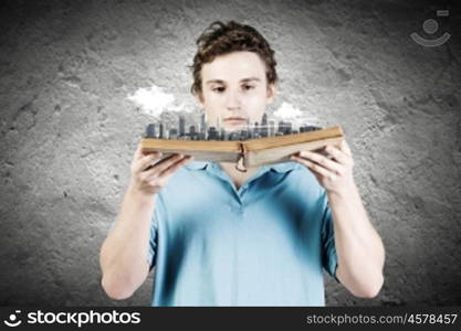 Man with book. Young man in casual holding opened book with city model