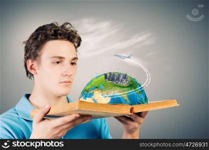 Man with book. Young man in casual holding opened book with city model. Elements of this image are furnished by NASA