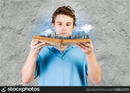 Man with book. Young man in casual holding opened book with city model