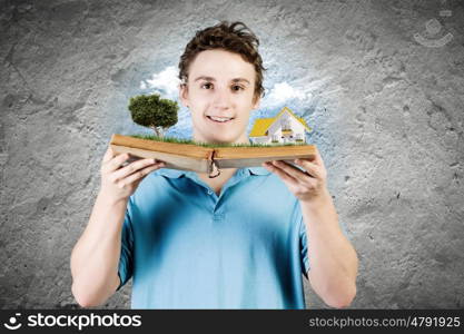 Man with book. Young man in casual holding opened book with green tree