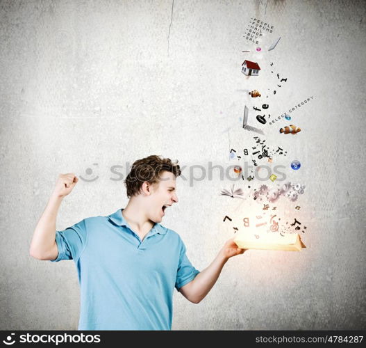 Man with book. Young man in casual holding opened book with icons flying out