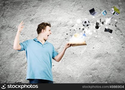 Man with book. Young man in casual holding opened book with icons flying out