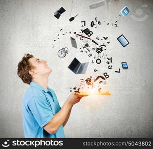 Man with book. Young man in casual holding opened book with icons flying out