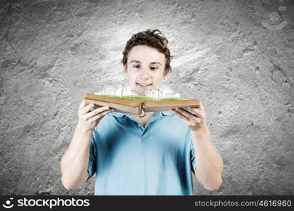 Man with book. Young man in casual holding opened book with windmills